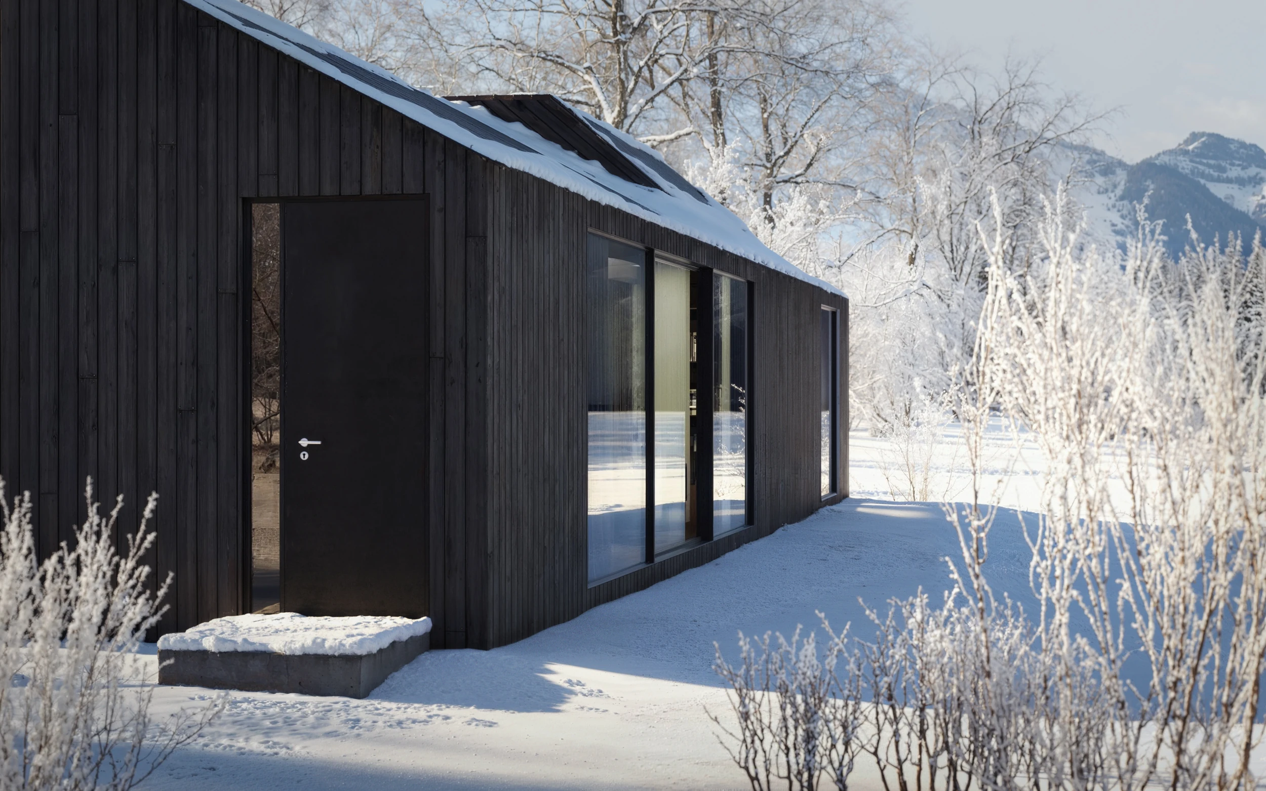 Haus S Seevilla mit schwarzer Fassade im Winter